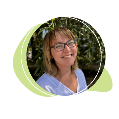 KI generiert: Eine lächelnde Person mit Brille, vor einem unscharfen Hintergrund mit Blättern.