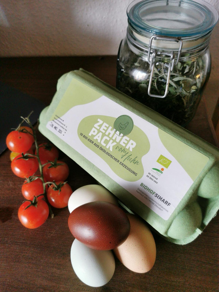 KI generiert: Eine Eierverpackung "Zehner Pack" mit Bio-Eiern, Tomaten, Glas mit Kräutern.