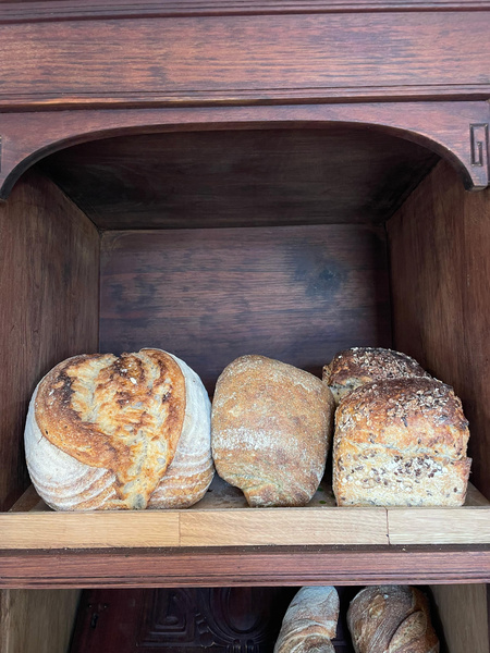 KI generiert: Verschiedene Brote in einem Holzregal.